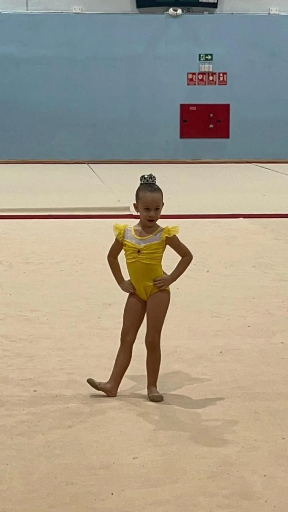 Alumna con maillot amarillo actuando junto a un árbol de Navidad de globos